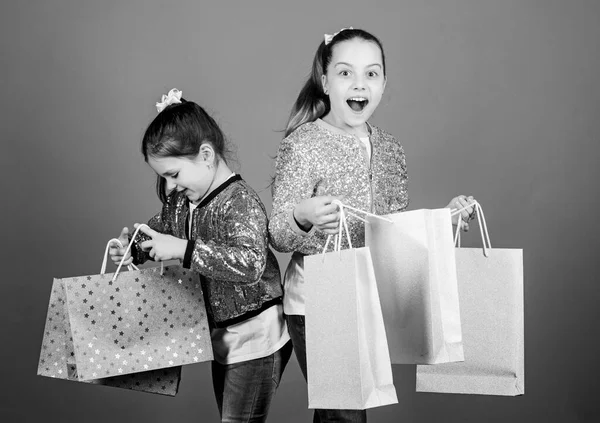 ブラック・フライデー。販売と割引。買い物の日だ。子供用の荷物だ。子供服。女の子姉妹のお友達でショッピングバッグバイオレット背景。なぜなら画像はすべてだからです。買い物・購入 — ストック写真