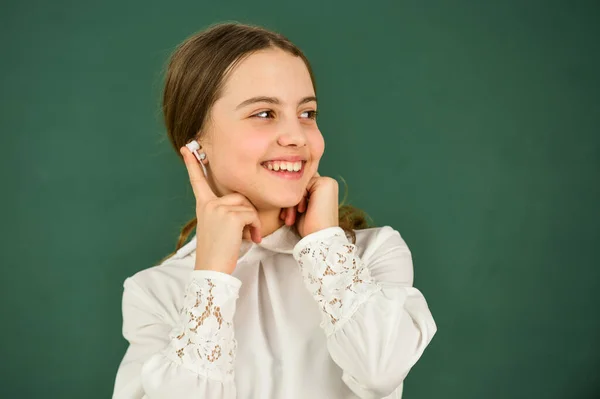 Verdadera felicidad. de vuelta a la escuela. niña pequeña con auriculares en la pizarra. escuchando audiolibros. ebook gratis. chica con auriculares escuchando música. concepto de e-learning. educación en el hogar educación en línea —  Fotos de Stock