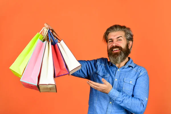 Ir de compras. Extremadamente feliz hipster haciendo compras en la tienda de electrónica. Hombre positivo disfrutando de las compras. Negocio propio. Barbudo hombre mantenga bolsa de papel. regalos. Hombre encantado de compras en línea —  Fotos de Stock