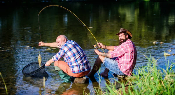 Šťastné přátelství rybářů. Dva kamarádi spolu rybaří. velká rybaření. relaxovat na přírodě. muškařský koníček mužů. Otec v důchodu a dospělý vousatý syn. Učení od profesionála — Stock fotografie