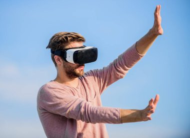 Yeni deneyimlerin tadını çıkarıyorum. Kendi işini kur. Sanal oyun oyna. Seksi adam gökyüzü arkaplan gözlüğü. Dijital dünyadaki erkek gerçekliği. VR kulaklığı kullan. Maço adam kablosuz VR gözlük takıyor..