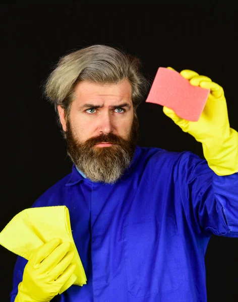 Devoir et nettoyer. mâle utilisant une éponge. Prenez soin de l'hygiène. homme barbu en gants de caoutchouc jaune essuyant la poussière à l'aide d'un plumeau. nettoyage à la maison. Concept de ménage. Ambiance domestique — Photo