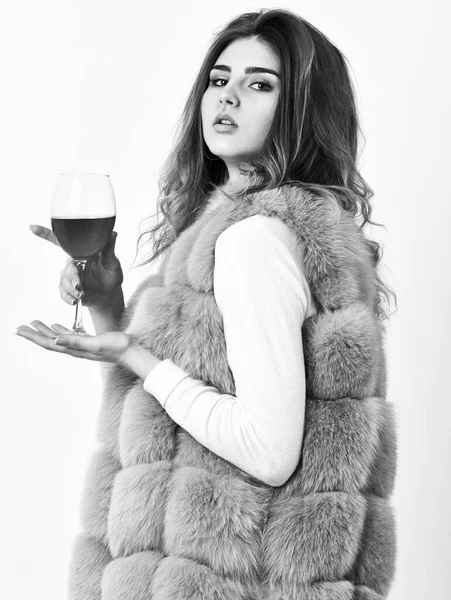 Concepto de hedonismo. Razones para beber vino tinto en invierno. La mujer bebe vino. Chica moda maquillaje desgaste abrigo de piel celebrar copa de vino. Señora modelo de moda peinado rizado le gusta vino de lujo caro —  Fotos de Stock