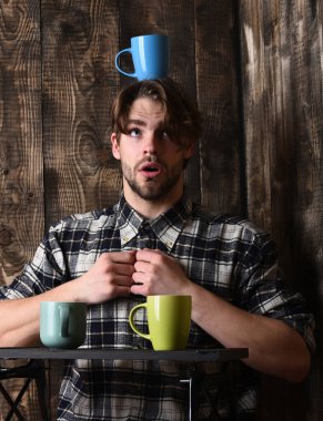 Ahşap arka planda bardakları tutan yakışıklı adam.