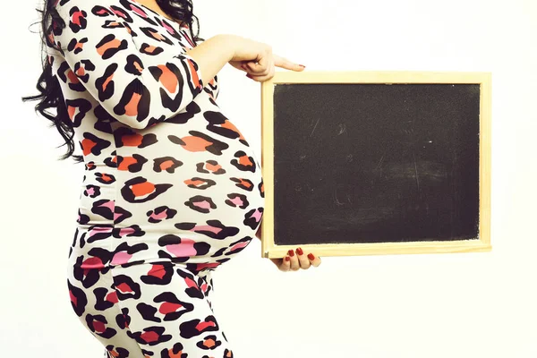 Manos femeninas de mujer embarazada sosteniendo tablero negro — Foto de Stock