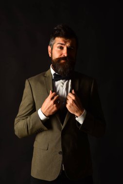 Eskimiş şık takım elbiseli ve kahverengi arka planda yelek giyen adam..