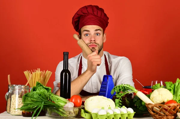 Aşçı şapkalı ve önlüklü adam yemek yapmaya hazırlanıyor. — Stok fotoğraf