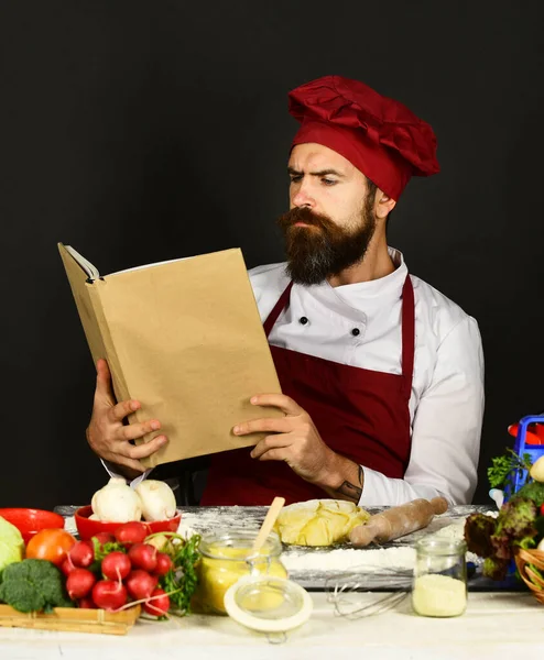 Burgonya üniformalı aşçı, yemek kitabı okur.. — Stok fotoğraf