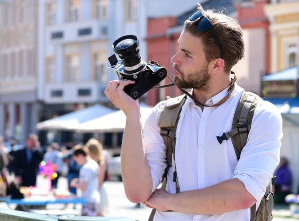수염을 기르는 남자 가 도시의 배경에서 사진 카메라를 들고 있다 — 스톡 사진