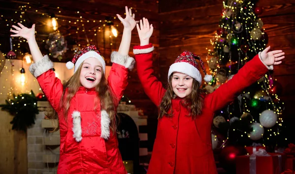 Små flicksystrar i röda hattar. Vi är en familj. Alvbarn. Det är jul. Tomten klor små flickor systrar. Julen. Familjesemester. Lyckliga systrar. Gott nytt år. Familjefest. Låt oss fira — Stockfoto