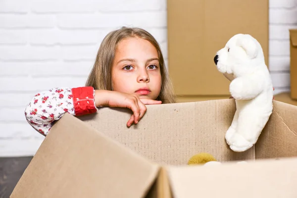 Después de la tienda de juguetes. caja de cartón infantil feliz. compra de vivienda nueva. niña feliz con juguete. reparación de la habitación. apartamento nuevo. Cajas de cartón - mudanza a nueva casa — Foto de Stock