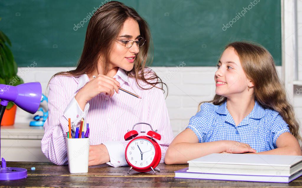 Its time to back to school. Teacher and little child at lesson. Pretty woman and small girl in school. During class time. School time. Private teaching. Education