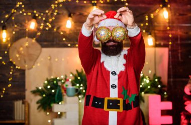 Parıldayan balolar Noel süslemeleri. Yılın en güzel zamanı. Dekorasyon dükkanı. Kış süslemeleri. Sakallı Noel Baba, Noel ağacını altın süslemelerle süslüyor. Satış ve indirim.