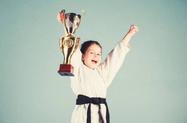 Kemerli beyaz kimonolu küçük çocuk. Karate dövüşçüsü çocuk. Karate spor konsepti. Kendini savunma becerileri. Karate güven hissi verir. Güçlü ve kendine güvenen küçük çocuk. Zafer ve kazanmak