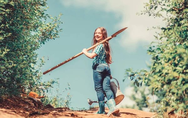 Éxito futuro. Una niña en Rancho. agricultura de verano. granjera niña. herramientas de jardín, pala y regadera. niño trabajador soleado al aire libre. vinculación familiar. pueblo junto al campo de primavera. Experto flores — Foto de Stock