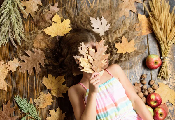 Herbstblätter fallen herunter. Kleines Mädchen mit welliger Frisur auf Herbst-Hintergrund. Hübsches Mädchen mit langer Frisur. Nettes Mädchen mit blonden Haaren. Kleines Schönheitsmodell im Herbst-Look. Friseursalon für Kinder — Stockfoto