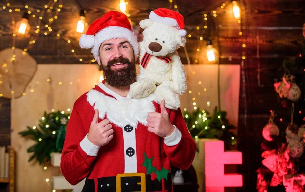 Merry Christmas to you. happy bearded man with bear. new year gifts. christmas decoration. santa claus hold teddy bear. merry christmas. man santa hat. winter holidays. wait for xmas presents