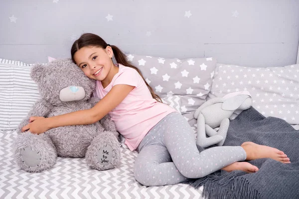 Ideal para acariciar. Niño feliz sostiene juguete oso de peluche en la cama. Niña jugar con juguete suave. Tienda de juguetes o tienda. Juguete de guardería. Hora de jugar. Juegos de infancia — Foto de Stock