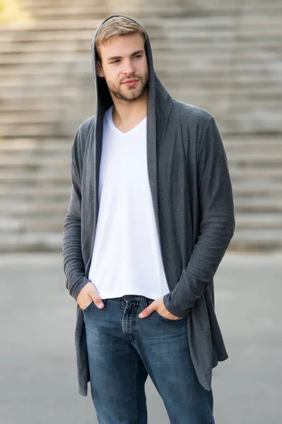 Great taste to dress well. Male fashion influencer. Fashionable young model man. Street style outfit. Handsome man with hood standing urban background. Fashion trend. Comfortable clothes daily wear