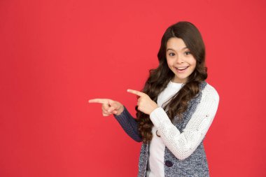 Küçük çocuk işaret ediyor. Terfi için bilgi. Bu ürünü satın al, kopyala alanı. Ürün sunan küçük bir çocuk. Satılık. Neşeli kız parmaklarıyla hareket ediyor ve kendini gösteriyor.