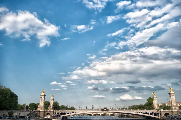 Paris, França - 01 de junho de 2017: ponte do convés sobre o rio Sena. Pont Alexandre III no céu azul nublado. Esculturas e arquitetura. Estilo arquitectónico. Património nacional. Monumento histórico. Viagens — Fotografia de Stock