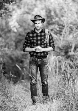 Sığır yetiştirme konsepti. Kırsal kesimde bir kovboy. Çiftlik işleri. Kement aleti. Amerikan kovboyu. Kementle bağlanmış. Batı hayatı. Kovboy doğası. Şapka tutan adam. Çiftlik sahibi