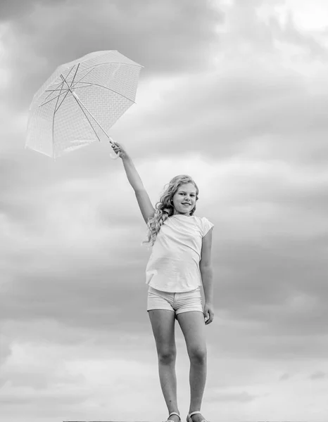 Hava değişiyor. Temiz hava. Şemsiyeli bulutlu arka planı olan bir kız. Özgürlük ve tazelik. Yerçekimi karşıtı kavram. Rahatlığın tadını çıkarıyorum. Tasasız çocuk dışarıda. Hava tahmini. Her havaya hazırım. — Stok fotoğraf