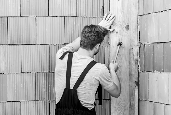 Werknemer met hamer baksteen muur achtergrond. Bouw en bouw. Ingenieur met hamergereedschap. Algemeen onderhouds- en reparatiepersoneel wordt ingehuurd voor onderhouds- en reparatietaken. Gebruik hamer — Stockfoto