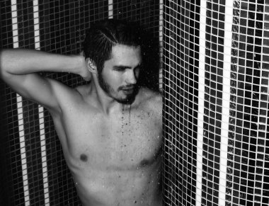 Yakışıklı kaslı seksi adam duşta yıkanıyor.