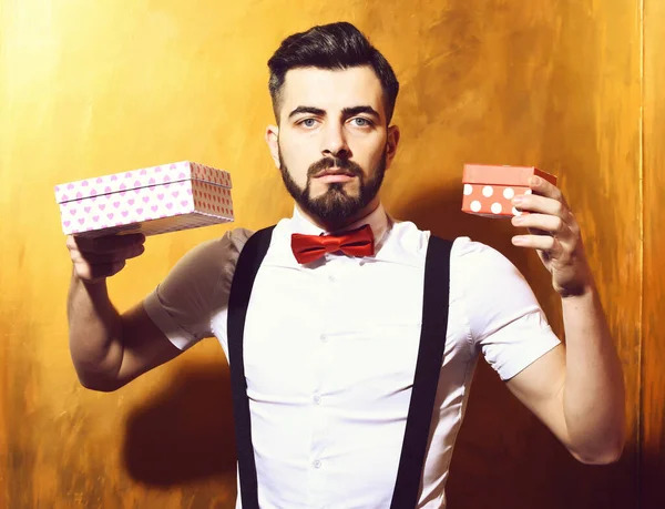 Homem barbudo segurando caixas atuais com rosto sério — Fotografia de Stock