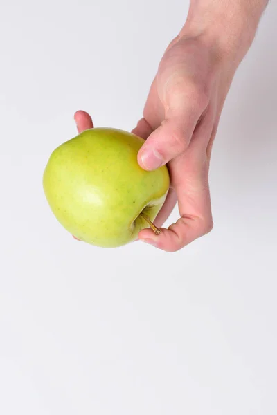 Männliche Hand hält hellgrünen Apfel. Apfel auf weißem Hintergrund — Stockfoto
