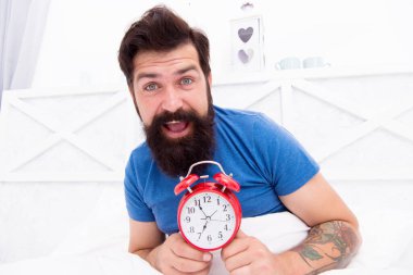 Sağlıklı uyku konsepti. Alarm saatini kapat ve sabah uyanmaya başla. Sabah hazırlanıyorum. Neredeyse yedi oldu. Adam sabahın 7 'sinde çalar saatle yatakta yatıyor. Günaydın sana.