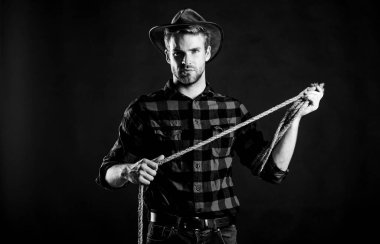 Teksas 'ta. Vahşi batı rodeosu. Siyah şapkalı adam. Batı kovboy portresi. Klasik tarz adam. Vahşi Batı eski kovboy. Kement ipli bir kovboy. Batı. Çiftlikte kareli gömlek