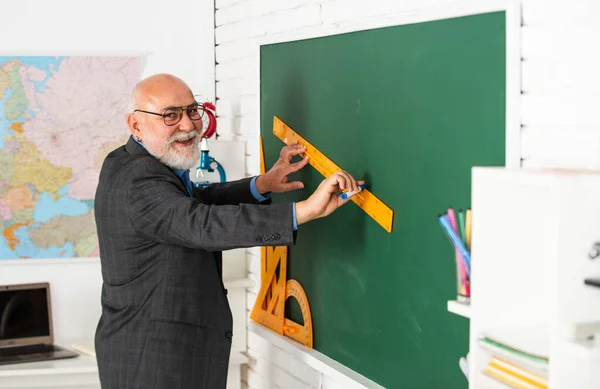Man bearded tutor in classroom. Teaching is passion. Main task in teaching. Formal education. Classic subjects learning. Improve teaching skills. Mature pedagogue. Teaching has changed in last years