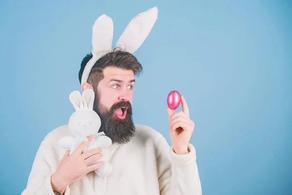 Що в ньому для мене. Пасхальний кролик доставляє кольорові яйця. Бородатий чоловік з іграшкою кролика та пасхальним яйцем. Гіпстер з довгими вухами кролика, що тримають заєць для відкладання яєць. Святкування весняних свят — стокове фото