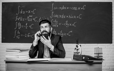 Aileleri arıyorum. Sınıfın yazı tahtası altındayken okul öğretmeni cep telefonunu aramış. Öğretmen sakallı adam cep telefonundan konuşuyor. Meslektaşını ara ve tavsiye iste. Pedagog meslektaşlarıyla irtibatta olsun.