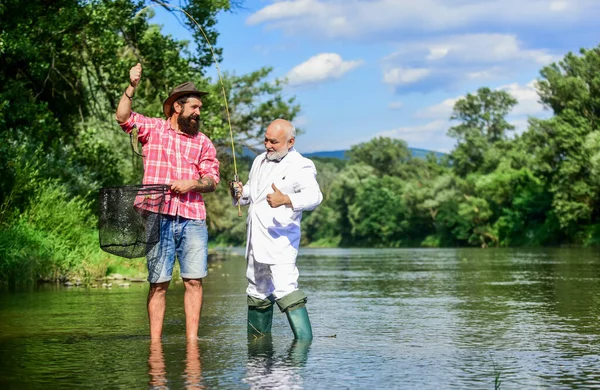 Diversión familiar. pasatiempo pez mosca de hombre de negocios. pesca de jubilación. feliz amistad de pescadores. padre jubilado e hijo barbudo maduro. Dos amigos pescando juntos. Concepto de captura y pesca —  Fotos de Stock