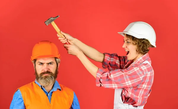 Några reparerar hemma. Man och kvinna bär skyddshjälm. Renovering av hemmet. Gnugga in. Ett par knackande huvud med hammare. Förklara. Intelligibelt koncept. Par renovera lägenhet tillsammans — Stockfoto