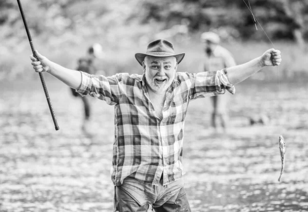 Balık yetiştiriciliği pisciculture ticari olarak balık yetiştirme. Emekli eğlencesi. Kancadaki balıklar. Adam kıdemli balıkçı. Balıkçı balıkçılık ekipmanları. Balıkçı tek başına nehir suyunda duruyor. Hobi spor aktivitesi