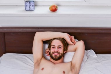 Sabah uyandıktan sonra gerin. Koyun altından dışarı bakan çıplak ayaklı bir adam. Uykulu adam pazartesi sabahı çalar saat sinyalini duyduktan sonra erken kalkıyor..