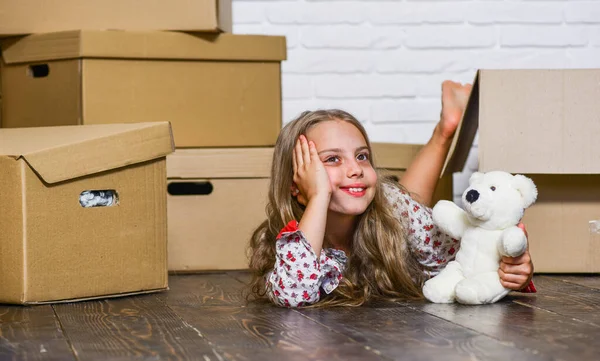 Niña pequeña y cajas. Quita el concepto. El chico se muda. Moviendo rutina. Empaquetar cosas. Prepárense para moverse. Alquiler de casa. Bienes raíces. Entrega de su compra. Soñando con habitación propia — Foto de Stock