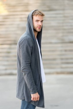 Kapüşonlu, kentte yaşayan yakışıklı bir adam. Moda modası. Günlük rahat giysiler. İyi giyinmenin zevki harika. Erkek modası etkisinde. Moda mankeni genç adam. Sokak tarzı kıyafet.