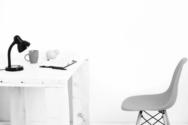 Tavolo in legno bianco con lampada nera, taccuino, tazza e portamonete — Foto Stock