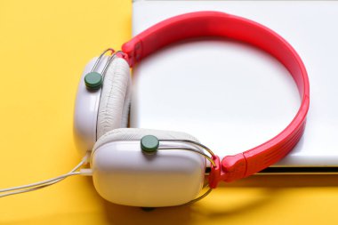 Plastikten kulaklıklar, turuncu arka planda bilgisayar.