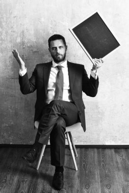 Ciddi bir iş adamı elinde tahta tutuyor.