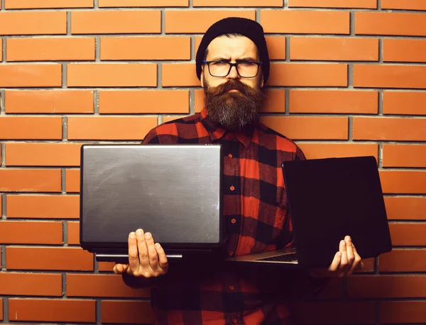 Bearded brutal caucasian hipster holding laptops — Stock Photo, Image