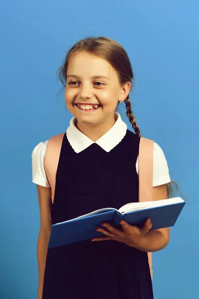 Ragazza tiene grande libro blu o notebook. Felice ragazza della scuola — Foto Stock