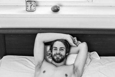 Sabah uyandıktan sonra gerin. Koyun altından dışarı bakan çıplak ayaklı bir adam. Uykulu adam pazartesi sabahı çalar saat sinyalini duyduktan sonra erken kalkıyor..