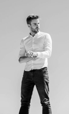 Genç uzmanlar. Kendine güvenen iş adamı Yakışıklı bir manken. resmi erkek modası. Modern yaşam tarzı. Başarı kavramı. Gökyüzü arka planı. Seksi maço adam. Erkek bakımı. Sakallı adam iş stili.