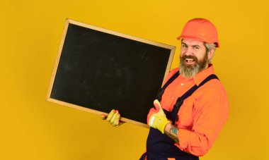 Yeni bir proje planlıyorum. Sunumuyla başarılı bir adam. İnşaatçı çizelgeyi işaret ediyor. Mimar işçi tahtayı tutuyor. Toplantıda sunum kurulu. Erkek inşaat işçisi. Boşluğu kopyala